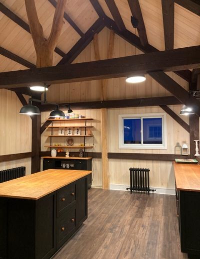 Stylish rustic kitchen with wooden accents, modern lighting, and custom cabinetry by Bytown Timberworks.